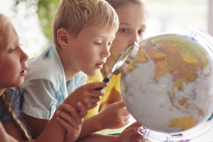 Children using magnifying glass in Geography