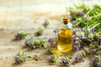 Essential oil of thyme in a bottle. Selective focus.