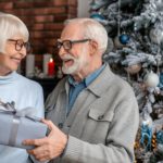 Senior man giving a christmas gift to his wife at home